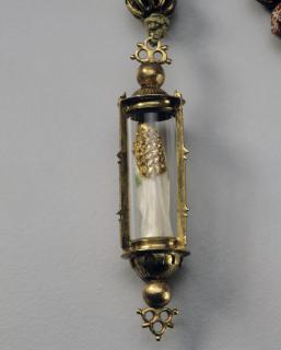Statuette; enclosed in a rosary pendant. (Back)